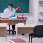 Young teacher in front of green board